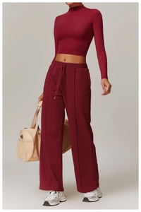 Detail of maroon long-sleeve crop top and high-waist drawstring joggers with front seams
