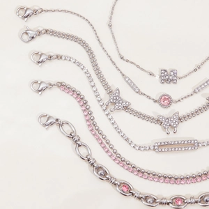 Macro view of silver stainless steel bracelets with pink zircon butterfly and M charms