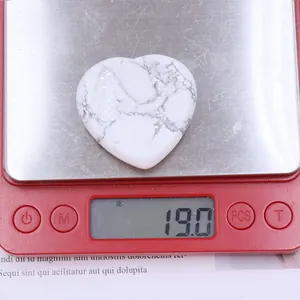 Macro shot of a 40mm white howlite heart stone showing 19.0g weight on a digital scale