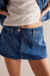 Dettaglio della gonna di jeans a vita alta con bottoni e consistenza in cotone