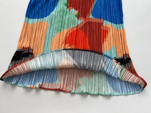 Detailed close-up of colorful abstract print and fine pleated fabric texture