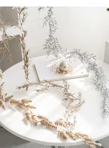 Macro shot of silver and gold Christmas glitter tinsel garland on a white table
