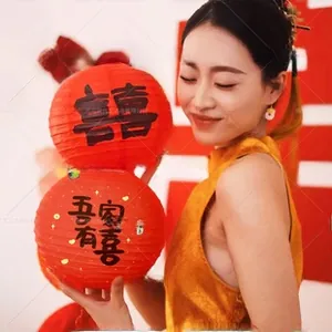 Detail of red Chinese paper lantern with black calligraphy and elegant gold sequins