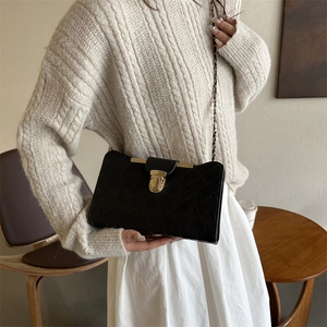 Classic black woven crossbody bag with gold rotating lock and elegant chain strap