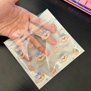 Detail of transparent self-sealing bag featuring cute puppy and blue bow cartoon designs
