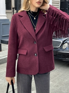 Detailed macro view of burgundy wool jacket featuring stylish long fringe trim on sleeves