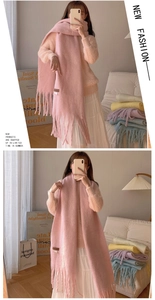 Close-up of soft pink long scarf with tassels and small leather tag detail
