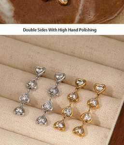 Detail of gold and silver heart drop earrings with cubic zirconia in a jewelry box