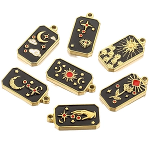 Rectangular tarot charms in black enamel with golden celestial moon and sun patterns