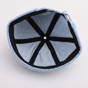 Detail of light blue docker hat interior with black reinforced seams and metal buckle