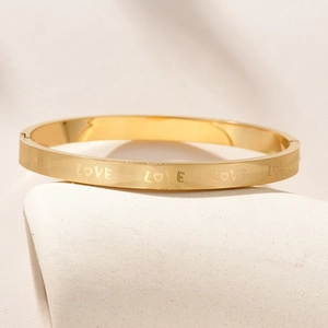Minimalist gold titanium steel LOVE engraved bangle with geometric textured pattern
