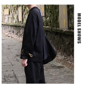 Side view of black casual streetwear lounge set worn by model on an outdoor stone path