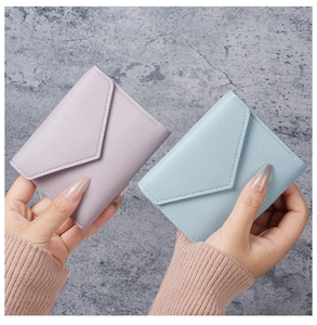 Detail von hellblauen und lila Mini-Umschlag-Brieftaschen mit Lychee-Textur und feiner Naht