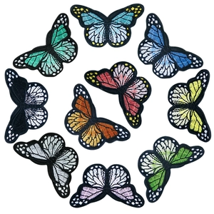 Detail view of ten colorful embroidered butterfly patches arranged on a white background