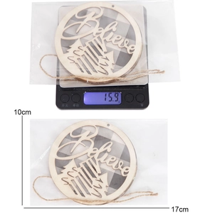 Detail view of a 10cm round wooden Christmas ornament with Believe laser-cut design
