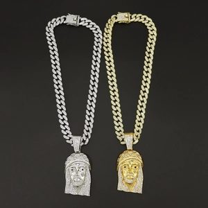 Close-up of gold and silver hip hop necklaces with diamond-encrusted Jesus pendants