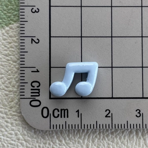 Detailed view of light blue resin musical note charm on a scale showing 1.5cm size