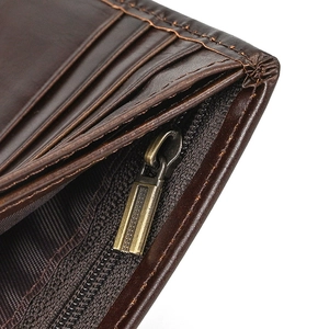 Macro shot of dark brown leather wallet interior with card slots and metal zipper pocket