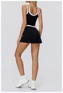 Close-up back view of a black two-piece yoga set featuring white contrast trim detailing