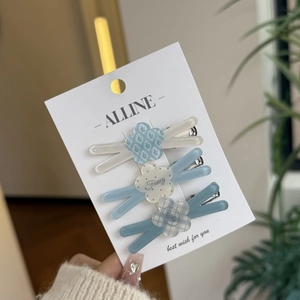 Detailed view of three resin floral hair clips in blue and white with silver metal base