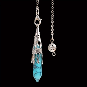 Detail van turquoise zeshoekige steen in een zilveren kooihanger voor een halsketting