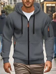 Detail of grey zip-up hoodie featuring a bright orange zipper pull and a functional sleeve pocket