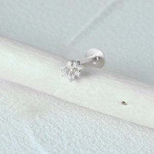 Macro detail of s925 silver ear stud with white pearl and sparkling crystals