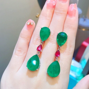 Orecchini pendenti a tre livelli con cristalli verde smeraldo e rossi in mano