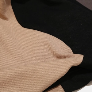 Detail of premium dual-color knit fabric in black and camel with fine stitching texture