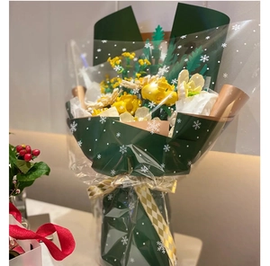 Close-up of yellow building block flowers wrapped in dark green snowflake pattern paper