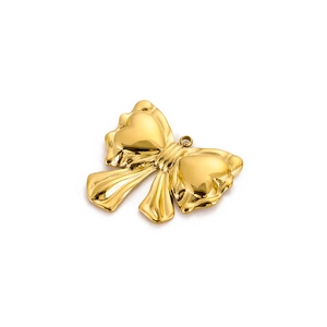 Macro detail of high-polished gold stainless steel bow pendant with fine textured details