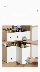 Close-up of a white plastic storage box with a finger hole for cabinet organization