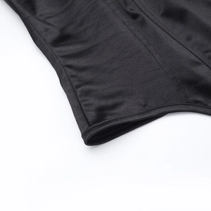 Dettaglio del corsetto nero che mostra il tessuto elastico e le doppie cuciture