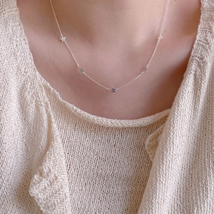 Minimalist 925 sterling silver star pendant necklace shown on female model's neck