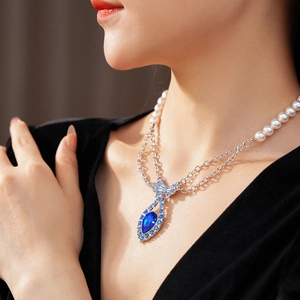 Detail of double-layer vintage necklace with blue drop pendant and pearl bead chain