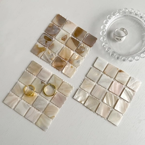 Macro view of natural mosaic shell tiles in brown and beige tones on a white table