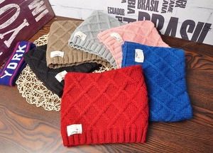 Detailed view of knitted winter hats for children in six vibrant colors on wood
