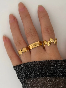 Nahaufnahme von dreiteiligem 18K vergoldetem Blumen- und Geometrie-Ring-Set für Damen