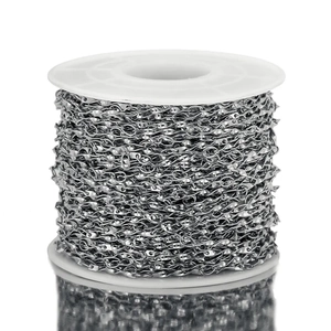 Macro shot of silver twisted Cuban chain on a spool for DIY jewelry making and crafts