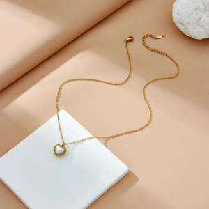Minimalist gold heart pendant necklace with white shell inlay for women on white stone