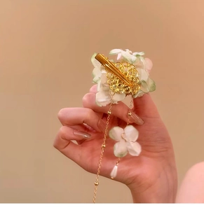 Detailed view of the fabric flower hair clip with pearl tassel and golden filigree