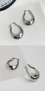 Detailed close-up of high-polished silver geometric C-shape hoop earrings for women