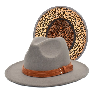 Detail of grey wool fedora hat featuring brown leather band and leopard print underbrim