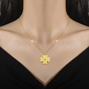 Titanium steel gold four-leaf clover necklace for women worn by a model on a black V-neck top