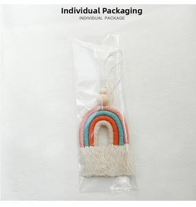 Detail of handmade rainbow car charm with cotton rope tassels and natural wood beads