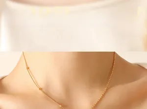 Gros plan sur l'élégant collier doré avec chaîne asymétrique à serpent et perles