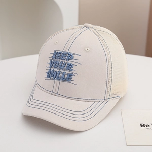 Close-up of blue Keep Your Smile embroidery and breathable mesh on off-white kids baseball cap