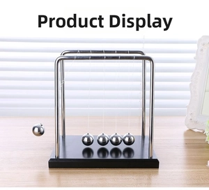 Close-up of Newton's cradle featuring 5 steel balls on a sleek black piano finish base