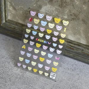 Dettaglio di adesivi per unghie orsetto macaron trasparenti con scritte rainbow su grigio
