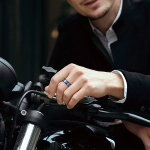 Men's black dragon-inlaid ring with blue texture shown on a motorcycle handlebar